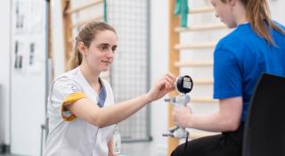 Ergotherapeut voert meting uit bij oncologische patiënt